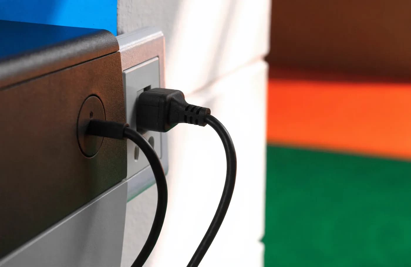 Gros plan sur le câble d'alimentation d'une imprimante branché dans une prise murale