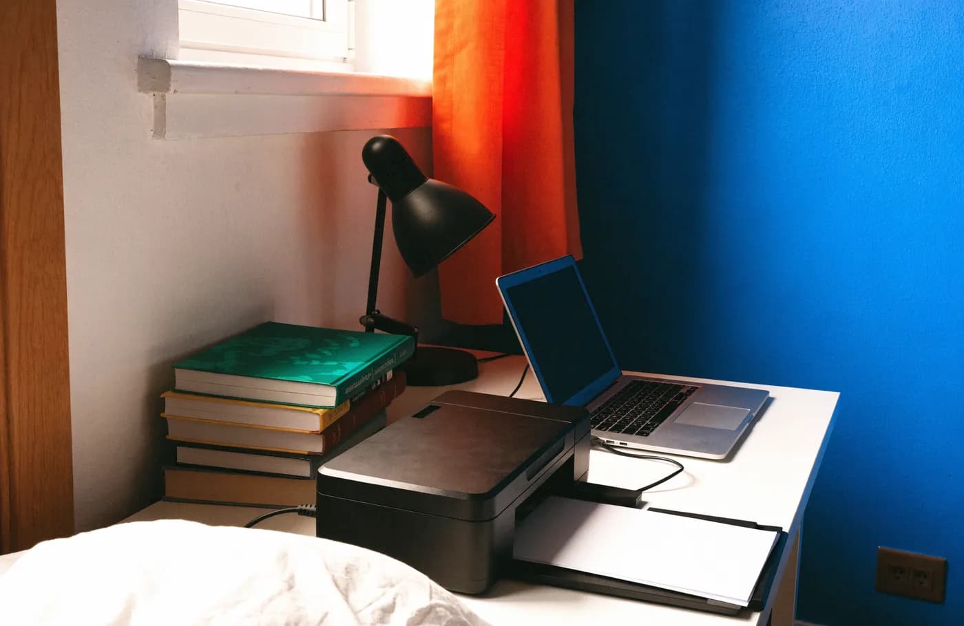 Imprimante compacte sur un bureau d'étudiant avec ordinateur portable, livres et lampe
