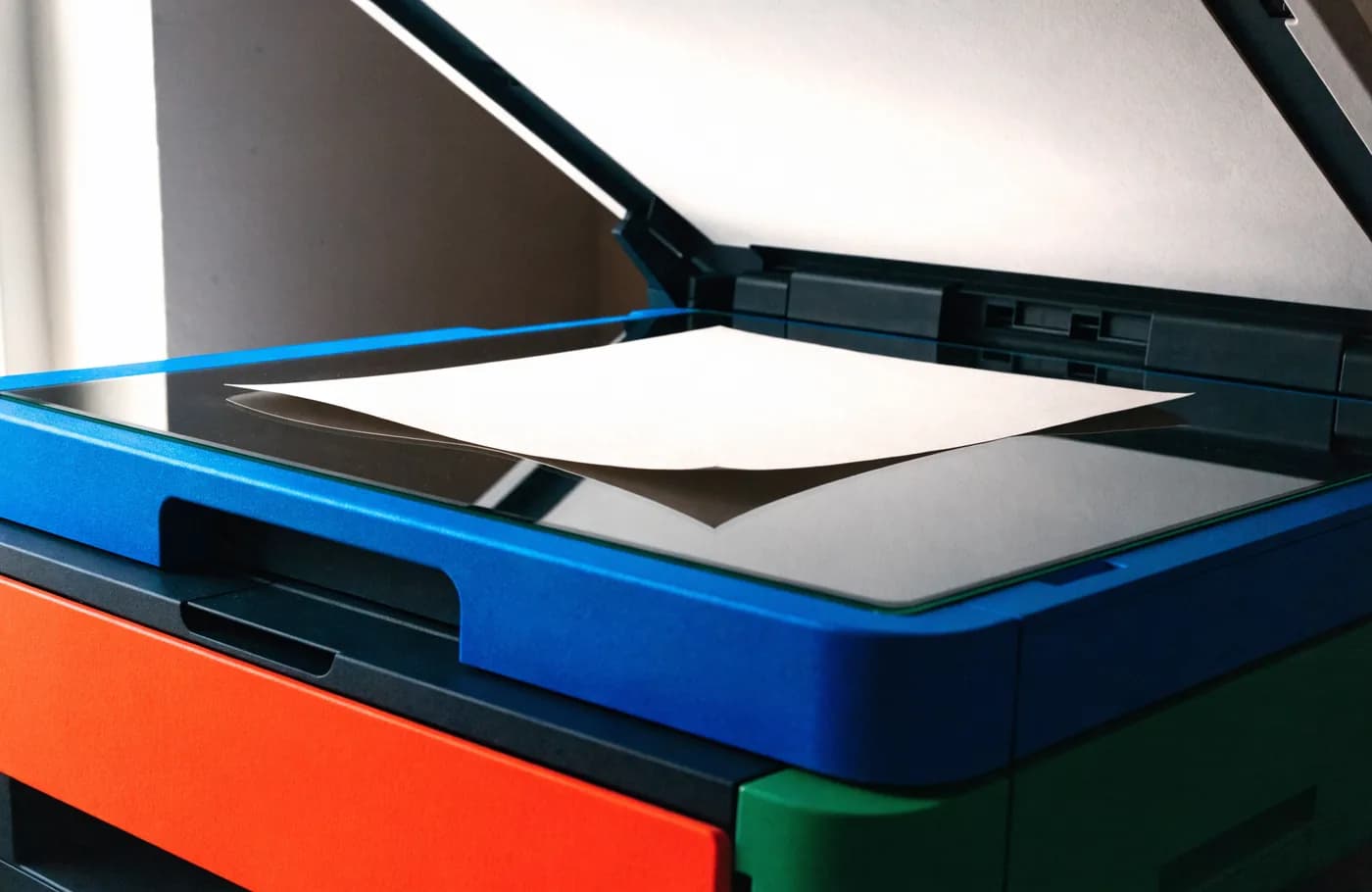 Capot de scanner relevé avec une feuille de document posée sur la vitre